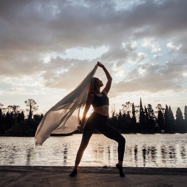 Woman in a graceful yoga pose, symbolizing fluidity and balance.